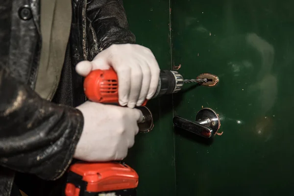 Inbreker proberen in te breken in een huis met boor — Stockfoto