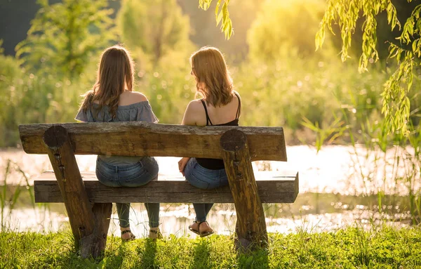 Two beautiful woman sitting on bench and relaxing — Stock Photo, Image