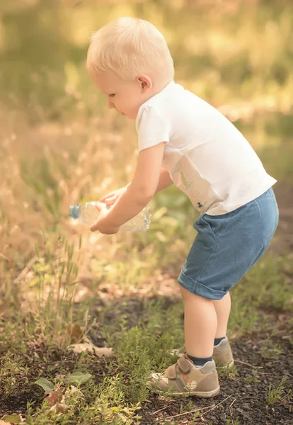 Küçük çocuk parkta çim sulama — Stok fotoğraf
