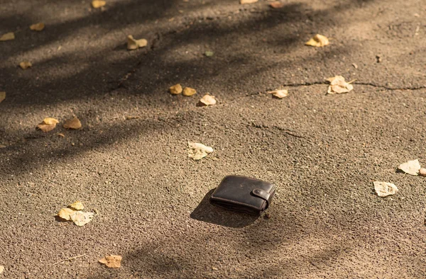 Hnědá kožená peněženka na chodníku — Stock fotografie