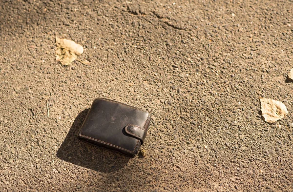 Cartera de cuero marrón en el pavimento —  Fotos de Stock