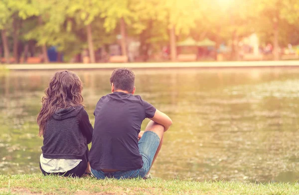 Jeune couple assis dans le parc — Photo