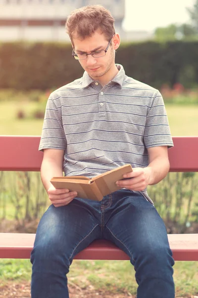 Молодий чоловік читає книгу в парку — стокове фото
