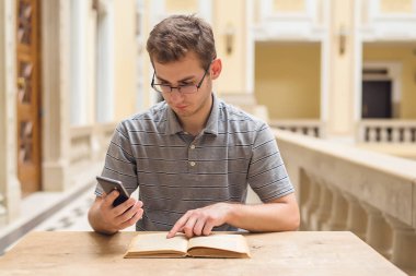 Genç öğrenci öğrenme adam ve onun telefon kullanma