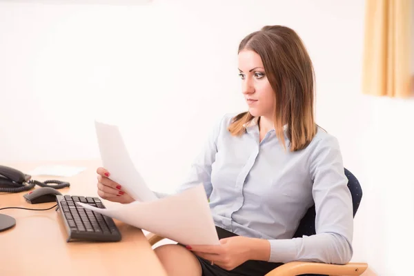 Niedliche Frau liest ein Dokument im Büro — Stockfoto