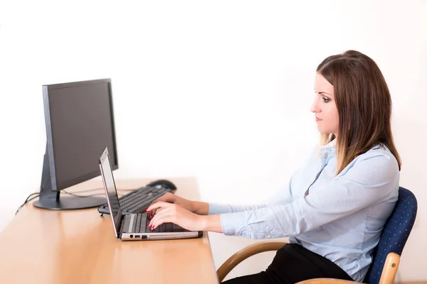 Ofiste dizüstü bilgisayar üzerinde çalışan sevimli kadın — Stok fotoğraf