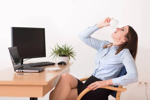 Geschäftsfrau trinkt einen Morgenkaffee im Büro — Stockfoto