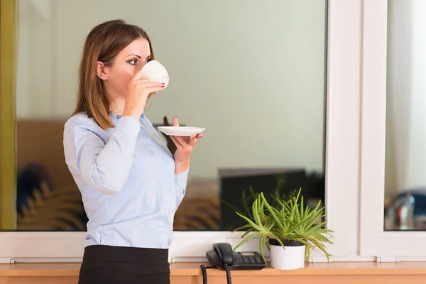 Mulher de negócios bebendo um café antes do trabalho no escritório — Fotografia de Stock
