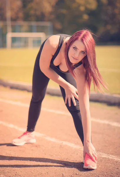 Mujer bonita se calienta en el gimnasio — Foto de Stock