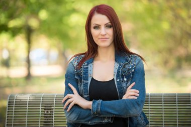 Doğada bankta oturan büyüleyici kadın