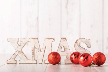 Xmas metin ve kırmızı topları bir tahta üzerinde