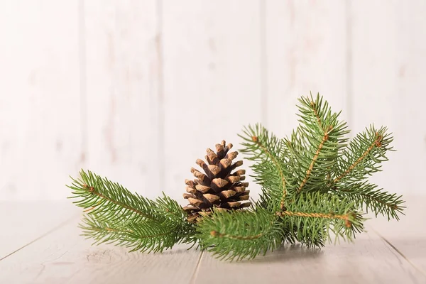 Pine branch and cone on wooden background — Stock Photo, Image