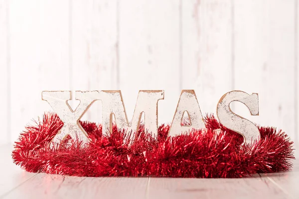 Vánoční text a červenou stuhou na dřevěné pozadí — Stock fotografie