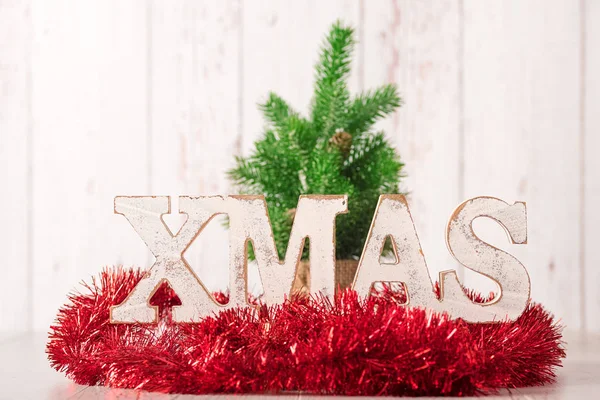 Vánoční text a červenou stuhou na dřevěné pozadí — Stock fotografie
