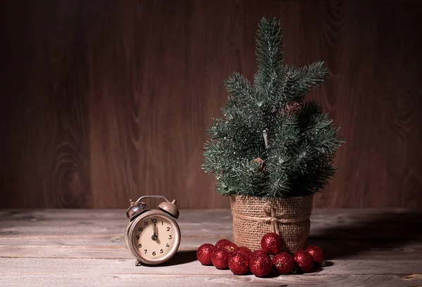 Küçük çam ağacı ve ahşap masa üzerinde eski saat — Stok fotoğraf