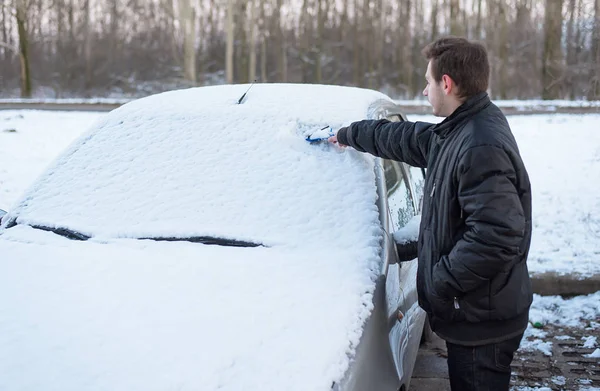 Gratter la neige et la glace du pare-brise de la voiture — Photo