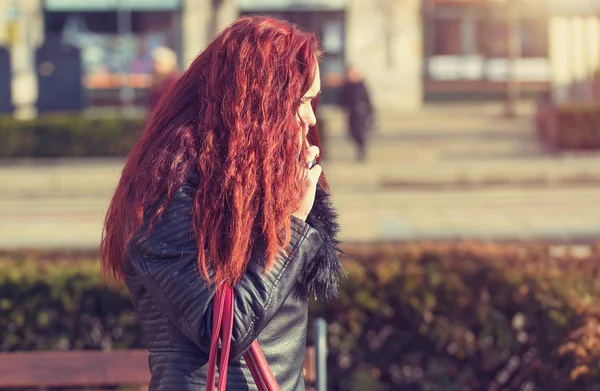 Belleza mujer pelo rojo caminando en la calle y el uso del teléfono — Foto de Stock