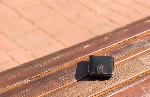 Ztracená kožená peněženka na lavičce — Stock fotografie