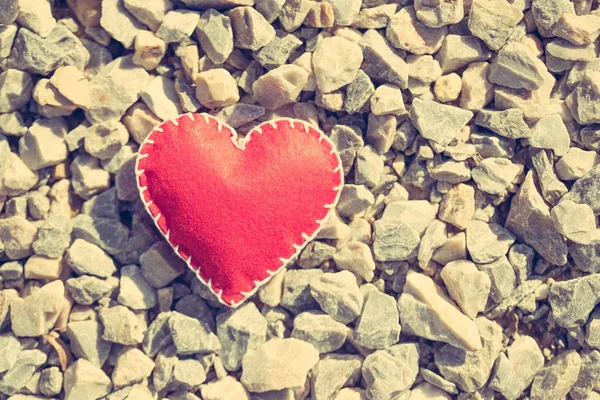 Stitched red heart on a gravel background — Stok fotoğraf