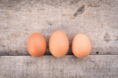 Eski ahşap arka planda üç yumurta. Yiyecek malzemesi..