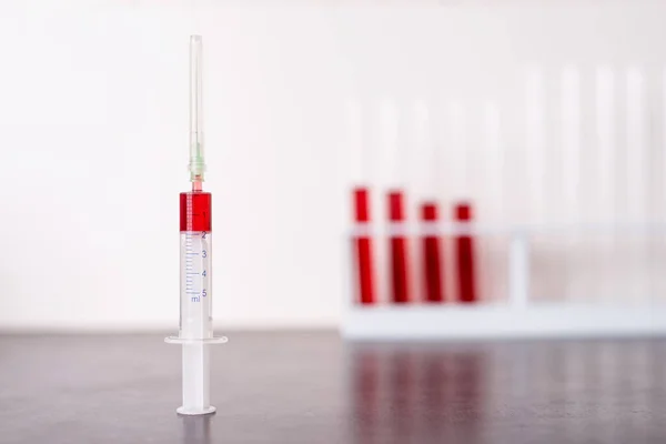 実験室のテーブルの注射器の血液サンプル — ストック写真