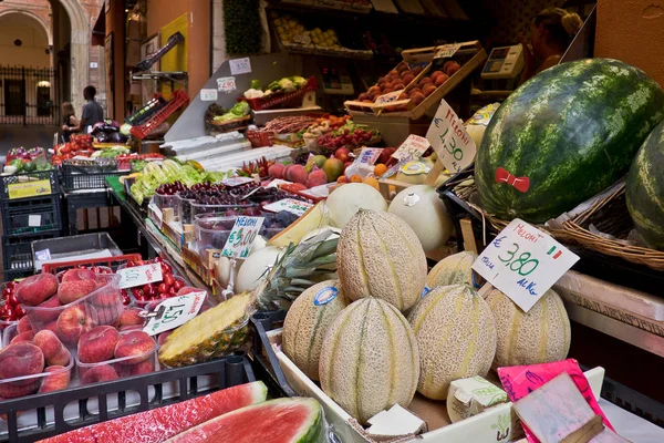 Sezónní ovoce a zelenina na stánky na otevřené pouliční trh v historickém centru Bologni s lidmi v pozadí — Stock fotografie