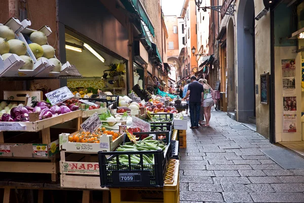 Frutta e verdura di stagione su bancarelle al mercato all'aperto nella storica città di mortadella con persone sullo sfondo che guardano le merci Immagine Stock