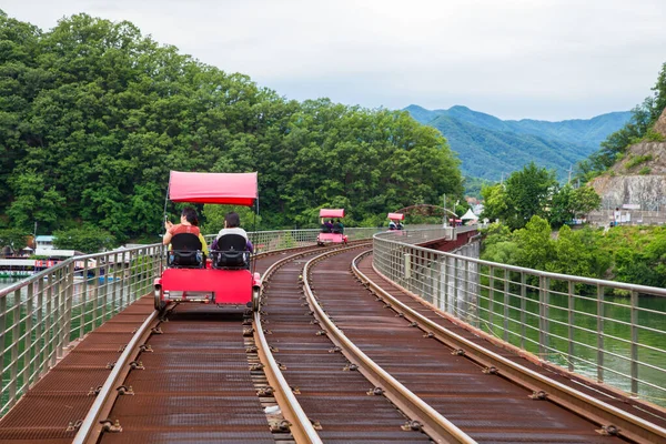 Gangchon Demiryolu Parkı, Chuncheon, Kore - 10 Haziran 2018 Güney Kore, Chuncheon 'daki Gangchon Demiryolu Parkı' nda pedal çevirirken mutlu bir turist ve doğa sahnesinin tadını çıkarın..