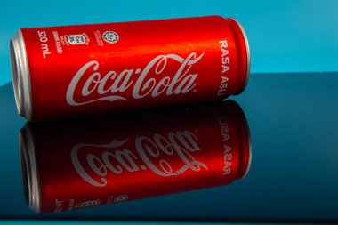 Kota Kinabalu, Sabah, Malezya-24 Mart 2020: Mavi arka planı ve yansıması olan bir teneke kutuda Coca Cola. Coca-Cola tüm dünyada satılan alkolsüz bir içecektir.