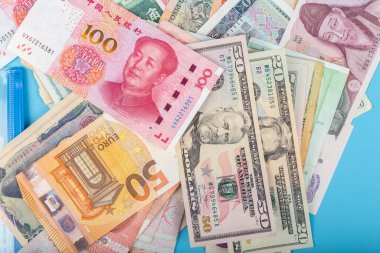 Uluslararası banknotların düz ya da üst görünümü farklı ülkelerin arka planında yer almaktadır. ABD Doları, Çin Yuanı, Japon Yen, Euro, Kore kazandı, Tayland bahtı. Forex veya küresel mali ekonomi kavramı.