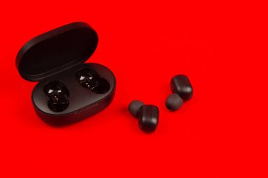 Kablosuz bluetooth kulaklıklar kırmızı arkaplanda izole edildi