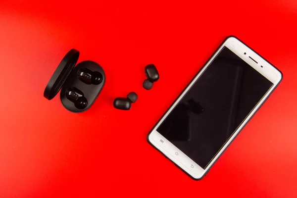 Smartphone Mit Drahtlosem Bluetooth Kopfhörer Isoliert Auf Rotem Hintergrund — Stockfoto