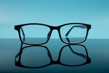 siyah çerçeve mavi arkaplanda yansıyan gözlük gözlüğü.