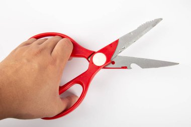 Beyaz arka planda kırmızı plastik saplı makaslı bir adam eli..