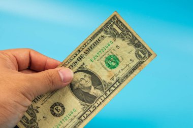 El ele tutuşan ABD Mavi arka planda bir dolarlık banknot