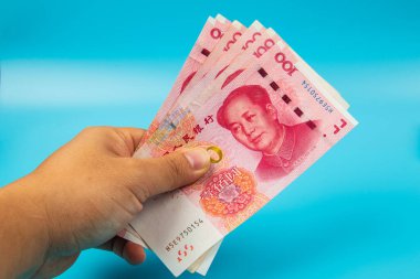 Çin 'i tutan adam. Mavi arka planda RMB100 Yuan Not.