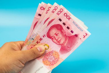 Çin 'i tutan adam. Mavi arka planda RMB100 Yuan Not.