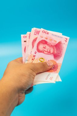 Çin 'i tutan adam. Mavi arka planda RMB100 Yuan Not.