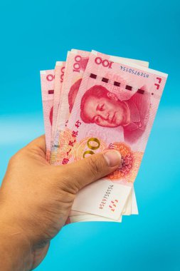 Çin 'i tutan adam. Mavi arka planda RMB100 Yuan Not.