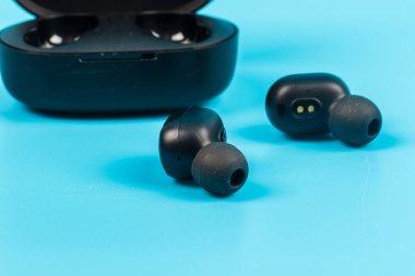 Mavi arkaplanda kablosuz bluetooth kulaklık var.