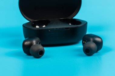 Mavi arkaplanda kablosuz bluetooth kulaklık var.