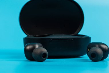 Mavi arkaplanda kablosuz bluetooth kulaklık var.