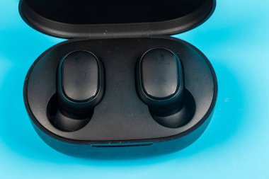 Mavi arkaplanda kablosuz bluetooth kulaklık var.