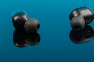 Yansıma yüzeyinde kablosuz bluetooth kulaklıklar.