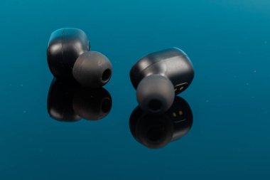 Yansıma yüzeyinde kablosuz bluetooth kulaklıklar.