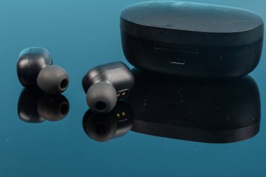 Yansıma yüzeyinde kablosuz bluetooth kulaklıklar.