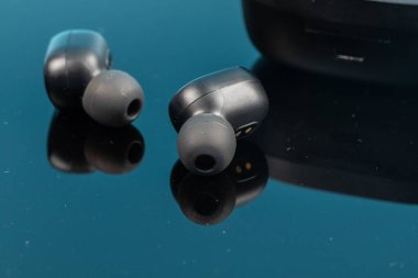 Yansıma yüzeyinde kablosuz bluetooth kulaklıklar.
