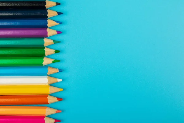 portrait of set of colorful pencils on blue background with copy space