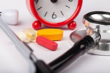 Steteskop, ilaç ve saat resmi. Tıbbi hatırlatma için..