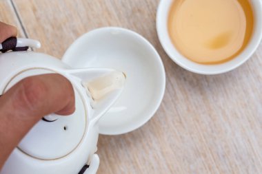 Adam Çin çay fincanına çay döküyor. Geleneksel Çin Çay Seremonisi Utensilleri Geleneksel Kültürü, Çin Çay Fincanı